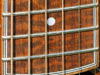 A snakewood fretboard with koa binding with 5 line purfling.
